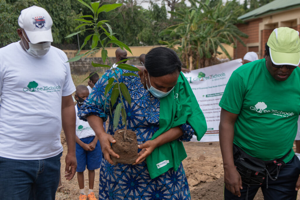 Head Teacher - Model Primary School, Maitama, school pupils, volunteers and founder of GivFree Africa, Ibrahim Garba Wala planting the first economic tree.